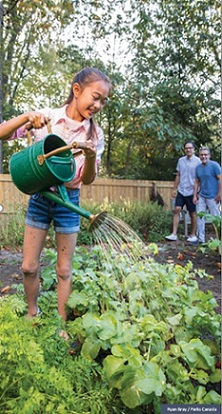 young girl waterting a garden